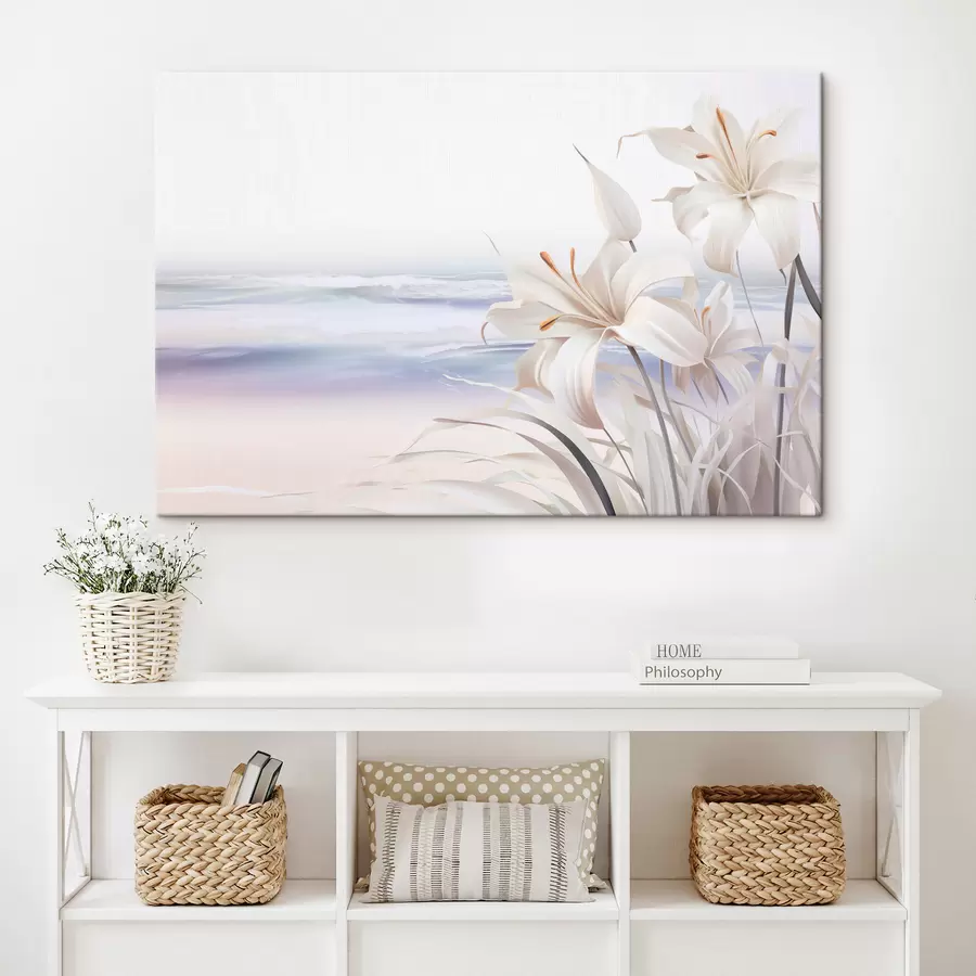 Pilt Valged liiliad oranžide õiekeste ja pikkade lehtedega rannas, taustaks pehmed lained, pastelsed värvid s44850