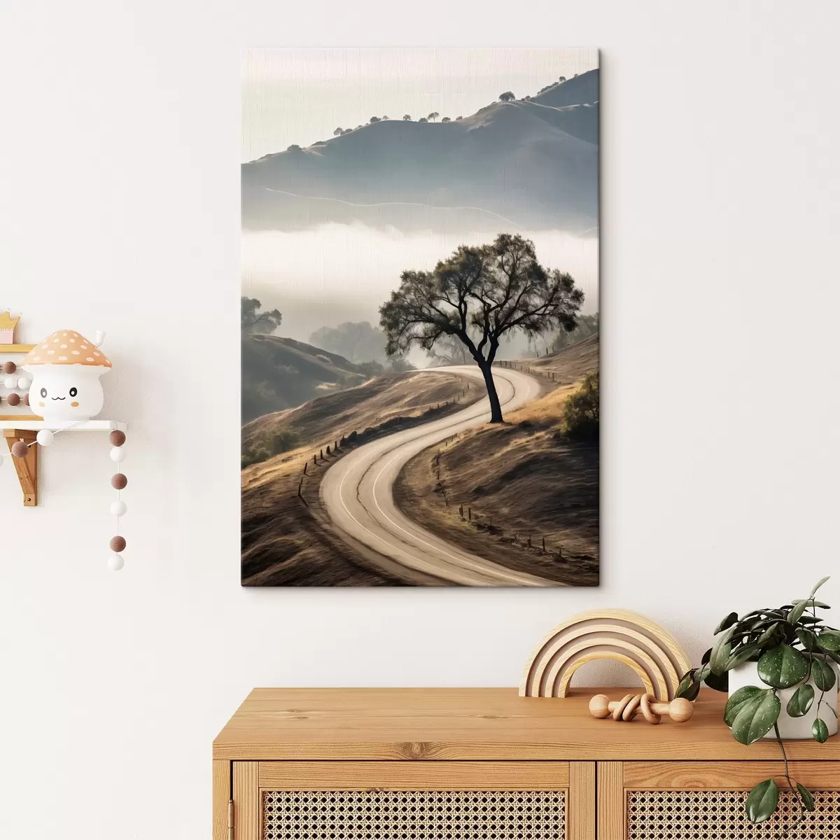 Pilt Käänuline tee läbi künklike mäenõlvade, esiplaanil puu, taustal udu ja mäed s46288