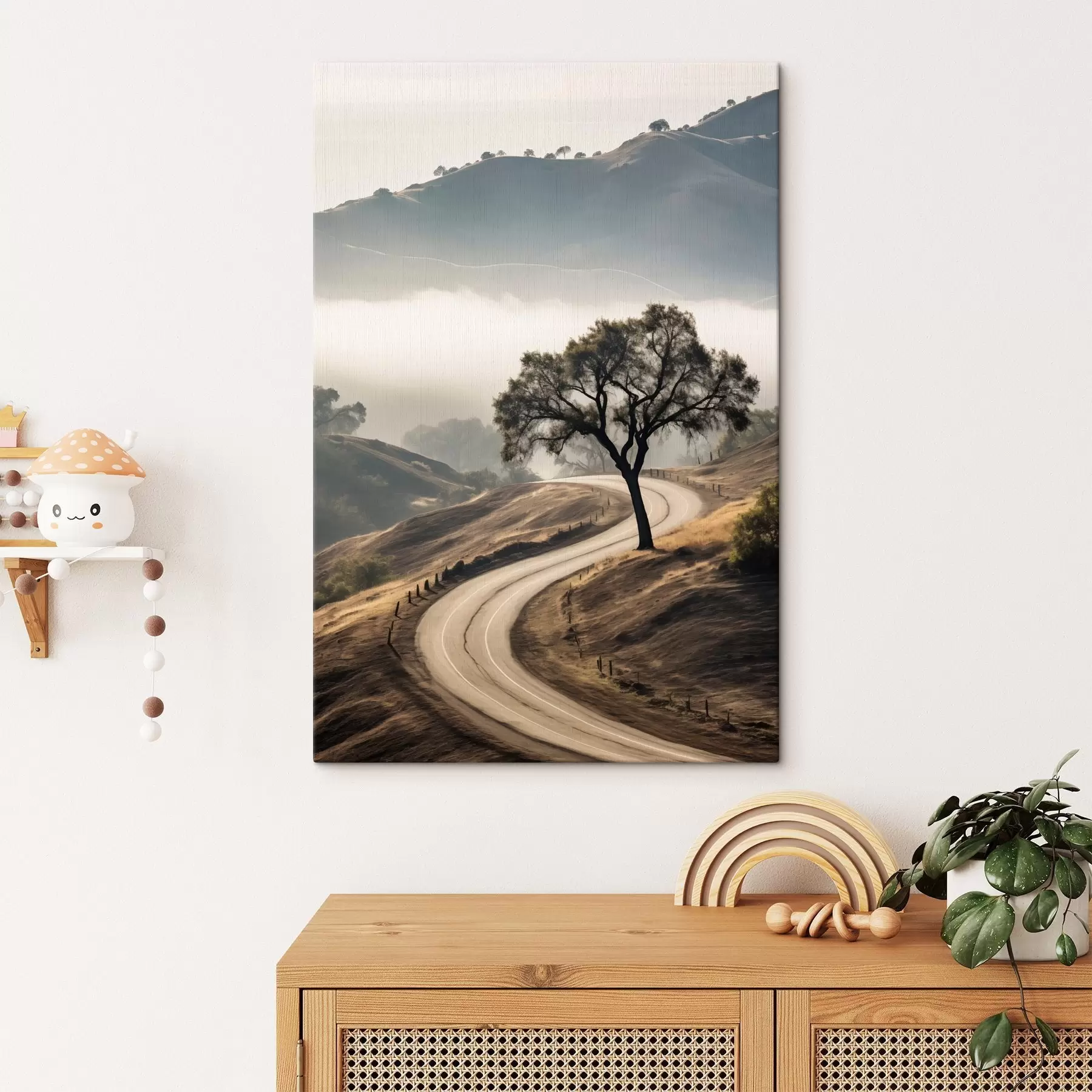 Pilt Käänuline tee läbi künklike mäenõlvade, esiplaanil puu, taustal udu ja mäed s46288