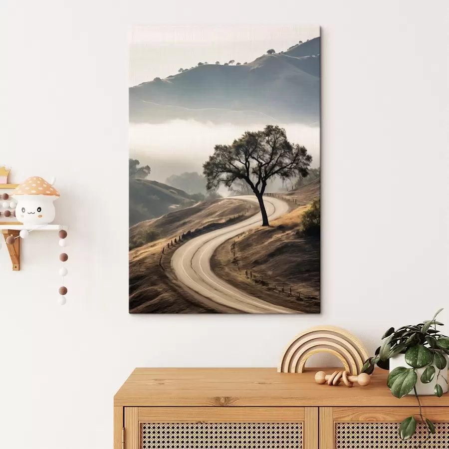 Pilt Käänuline tee läbi künklike mäenõlvade, esiplaanil puu, taustal udu ja mäed s46288