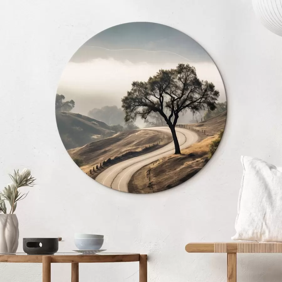 Pilt Käänuline tee läbi künklike mäenõlvade, esiplaanil puu, taustal udu ja mäed r46288