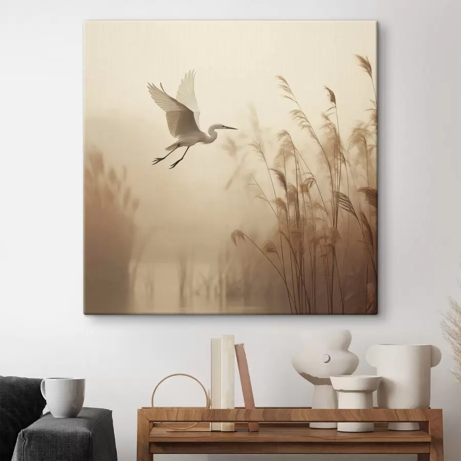 Pilt Valge kurg lendab järve kohal, mida ümbritsevad kõrged pilliroog ja puud taustal s48390